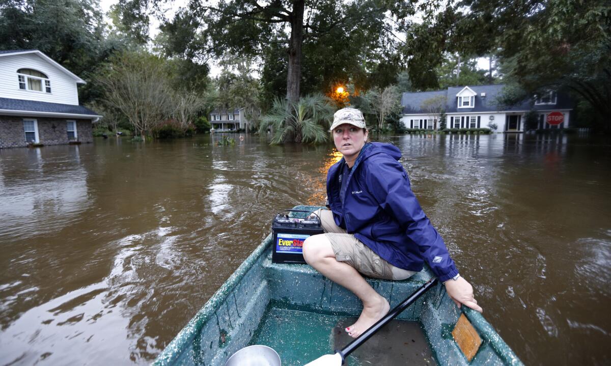 Jeanni Adame rides in her boat as she checks on neighbors seeing if they want to evacuate in the Ashborough subdivision near Summerville, S.C.