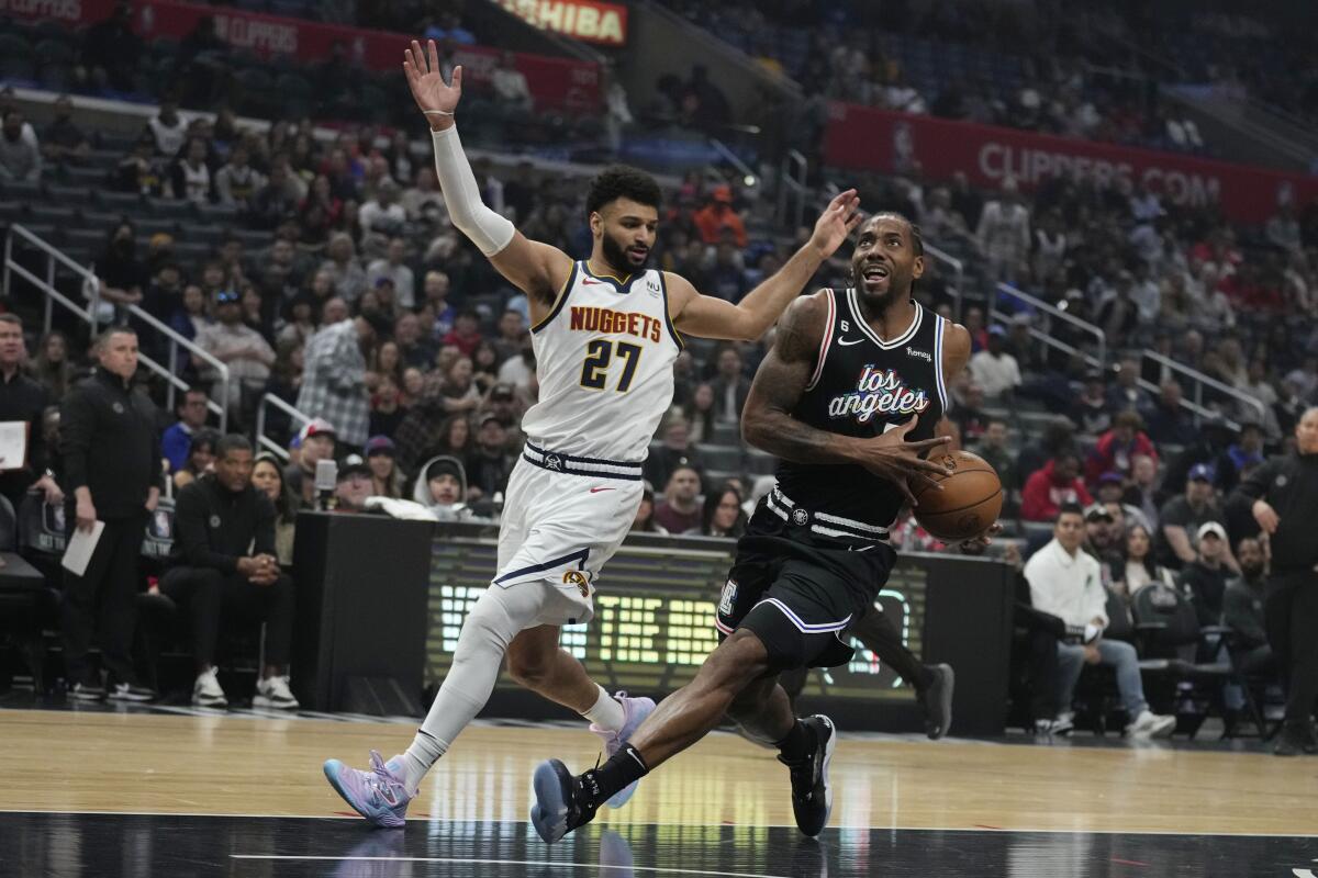 Clippers forward Kawhi Leonard, right, drives past Denver Nuggets guard Jamal Murray.