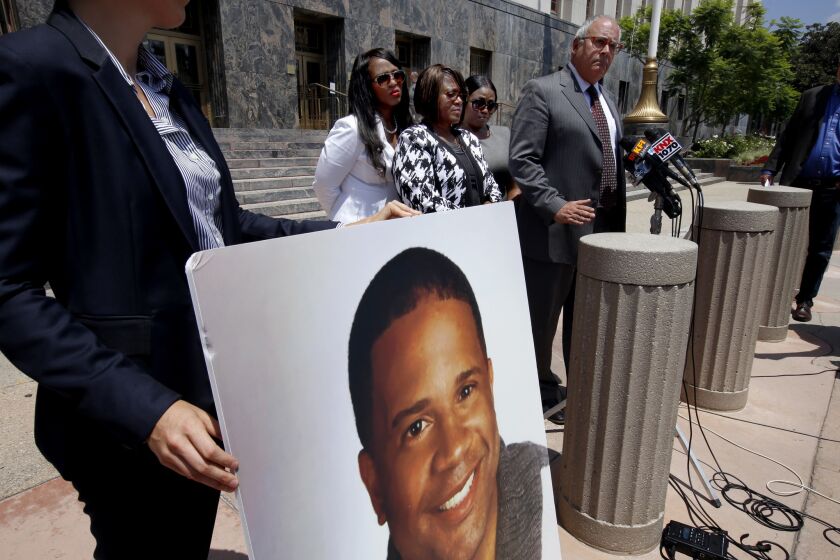 LOS ANGELES, CA JULY 31, 2017: As large photo of Dennis âToddâ Rogers is held next to Attorney Peter Morris, right, of the Law Firm of Barnes & Thornburg LLP, as he speaks during a press conference at the Spring Street Federal Building and Courthouse in Los Angeles, CA July 31, 2017. Standing next to him are Dennisâ older sister Cynthia Billingsley, left, mother Janet Williams, the mother, middle, and cousin B.R. Land, right. During the press conference her attorneys announced the filing of a federal civil rights lawsuit against the Sheriffâs Department and Los Angeles County. (Francine Orr/ Los Angeles Times)