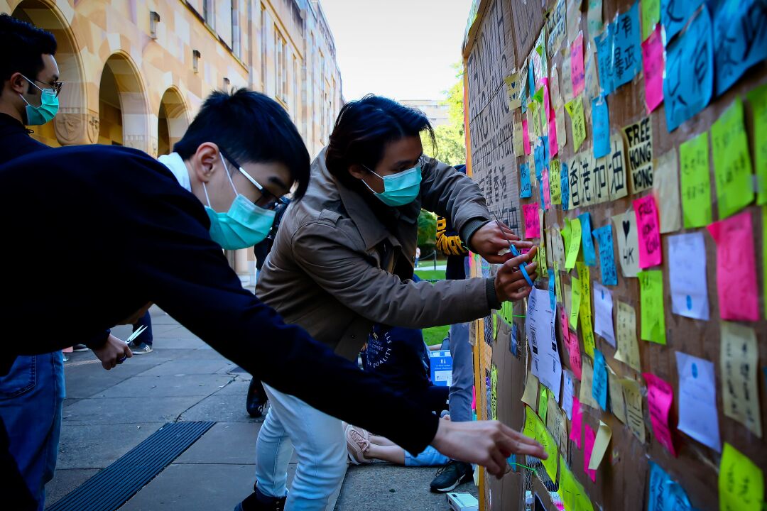 Supporters of the Hong Kong pro-democracy protests posting notes on a makeshift Lennon Wall.
