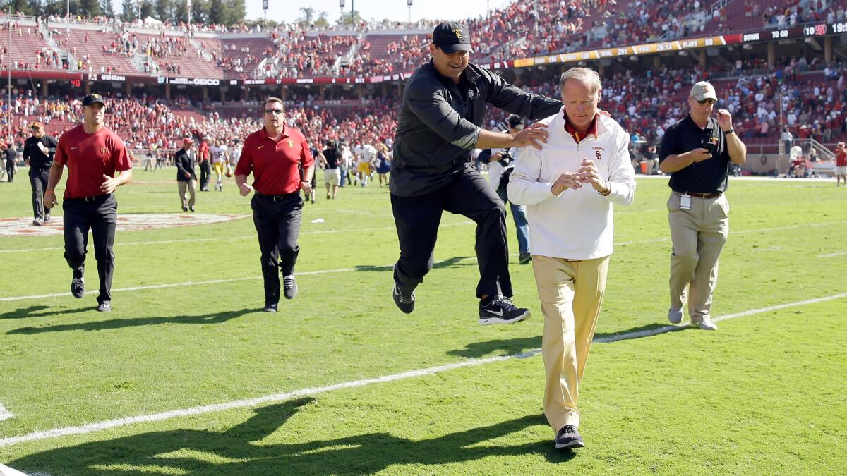 USC Coach Steve Sarkisian, center, jumps in celebration next to USC Athletic Director Pat Haden after the Trojans' win over Stanford in Palo Alto on Sept. 6. 2014.