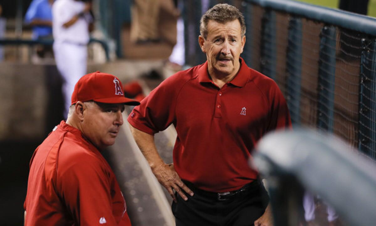 Angels owner Arte Moreno speaks with manager Mike Scioscia before a game in 2012.