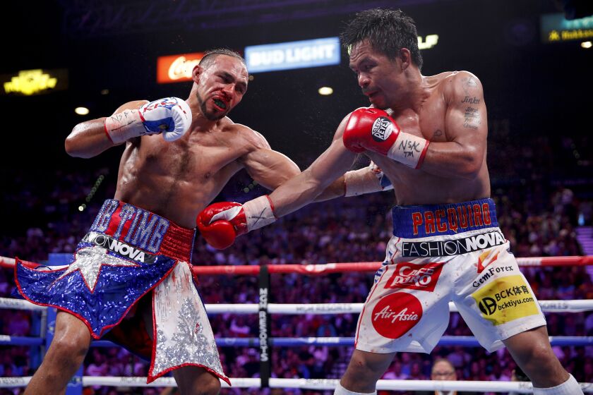 Keith Thurman, left, and Manny Pacquiao exchange punches in the eighth round during a welterweight title fight on Saturday in Las Vegas.