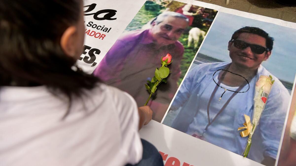 A mourner in Quito, Ecuador, places a flower next to the portraits of reporter Javier Ortega, photographer Paul Rivas and driver Efrain Segarra after learning of their deaths.