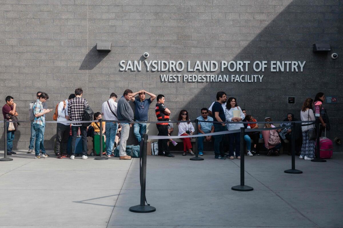 En esta foto de archivo tomada el 28 de octubre de 2018, la gente espera en línea afuera del Puerto de Entrada de San Ysidro, entre Tijuana, México y San Diego, California, en San Ysidro, California.
