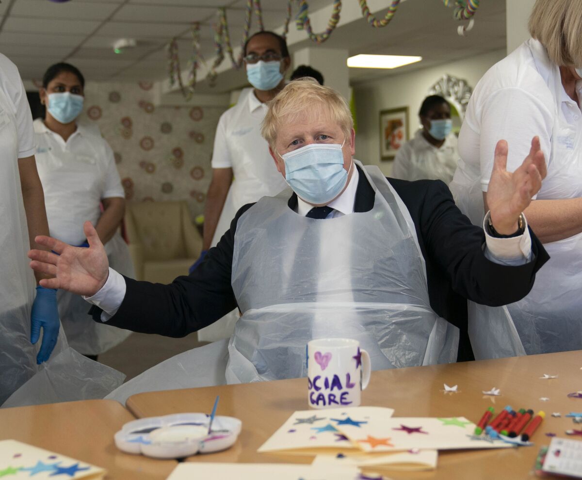 Britain's Prime Minister Boris Johnson takes part in an activity, during a visit to Westport Care Home in Stepney Green, east London, Tuesday, Sept. 7, 2021, ahead of unveiling his long-awaited plan to fix the broken social care system. (Paul Edwards/Pool Photo via AP)