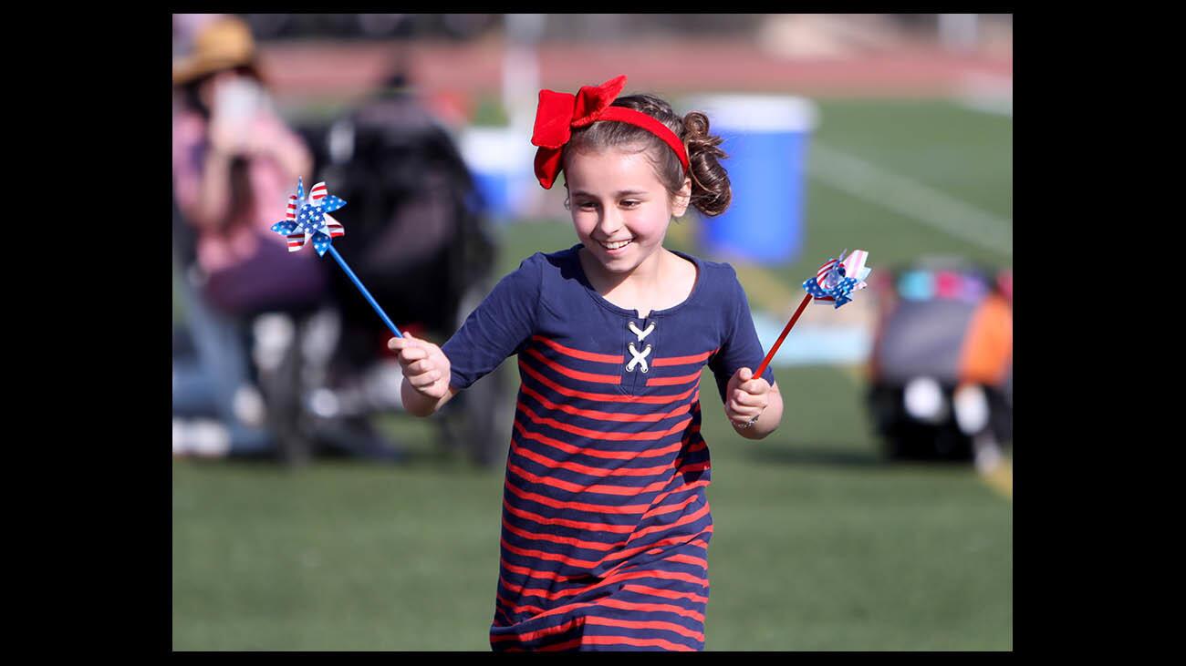Ten year-old Anevay McGovern, of Glendale, runs with festive spinners at the Crescenta Valley Fireworks Association 12th annual Fourth of July Fireworks Festival, at Crescenta Valley High School, in La Crescenta on Wednesday, July 4, 2018.