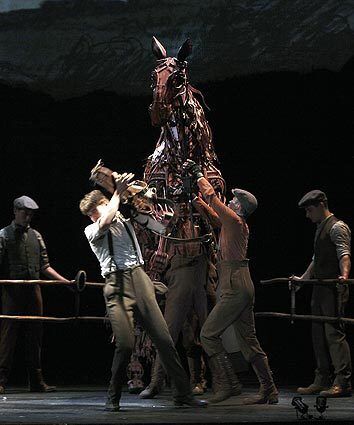 The horse Joey rears in protest when Andrew Veenstra tries to place a horse collar around its neck in the Tony-winning play "War Horse" at the Ahmanson Theatre.