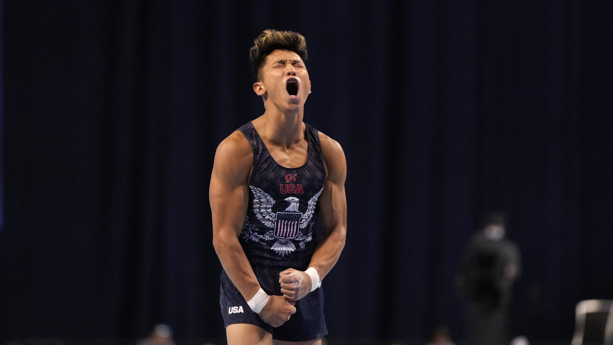 A gymnast shouts and pumps his muscles. 