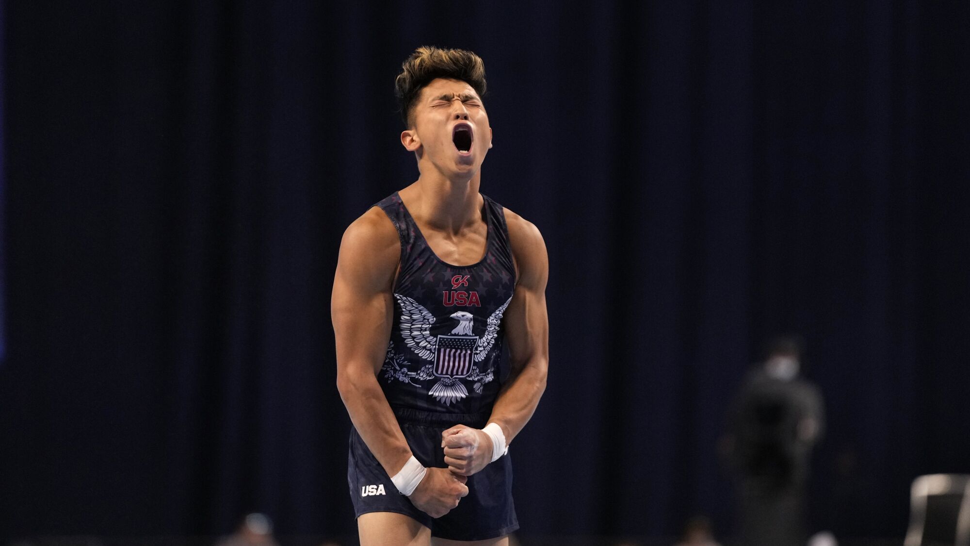 A gymnast shouts and pumps his muscles.