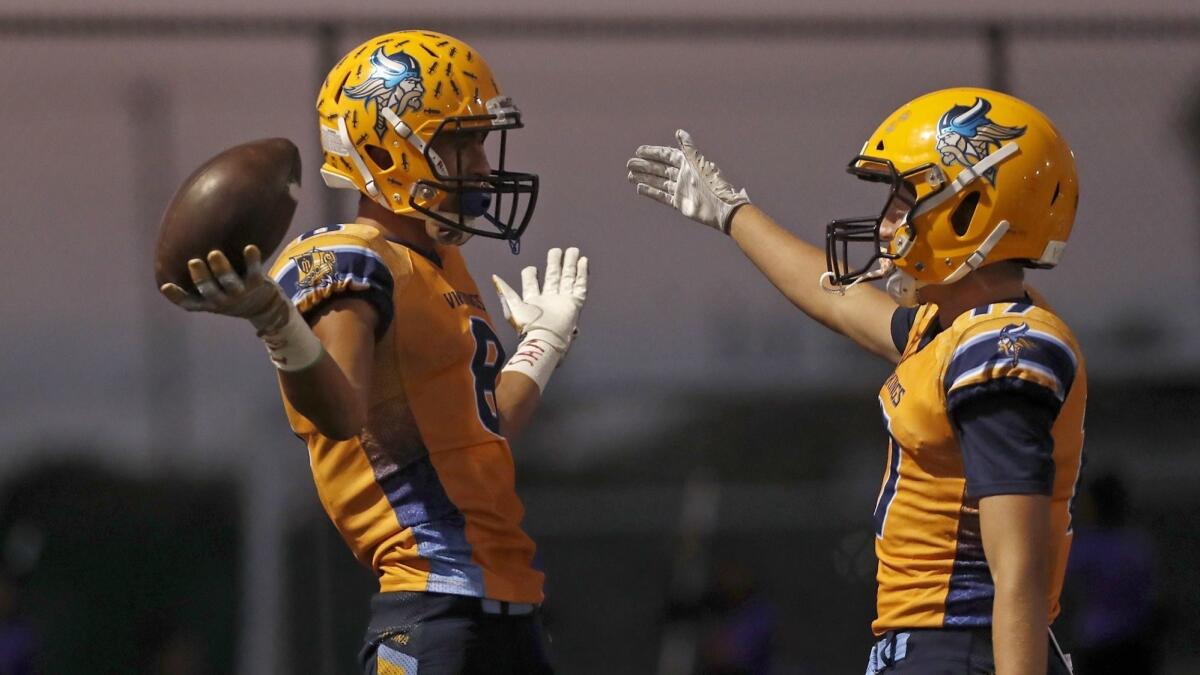Marina High's Nathan Pendleton, left, shown celebrating a touchdown with Gavin Dykema against Katella on Sept. 7, will try to help the Vikings beat Huntington Beach in the Oil vs. Water rivalry game on Friday.