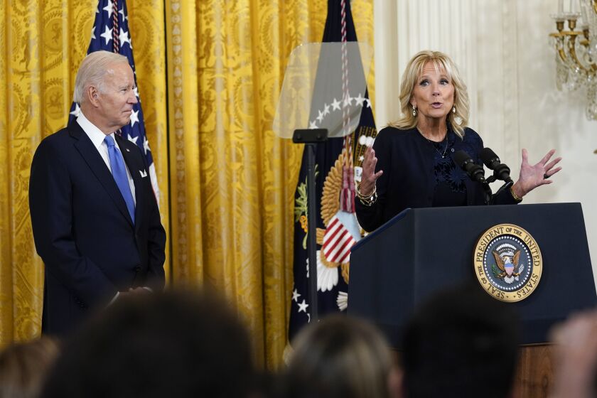 President Joe Biden listens as first lady Jill Biden speaks during a reception in the East Room of the White House for Hispanic Heritage Month in Washington, Friday, Sept. 30, 2022. (AP Photo/Susan Walsh)