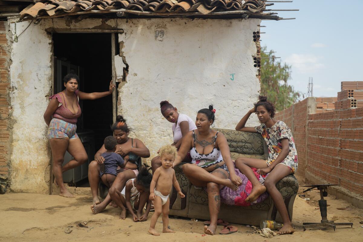 Aglete Batista (segunda desde la derecha) y su familia sentados frente a su casa en Aracuai (Brasil) 