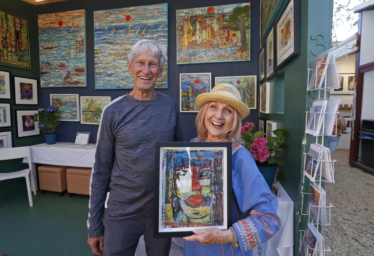 Artist and exhibitor Charleine Guy and friend Ken Aubuchon greet guests during the Sawdust Art Festival's Preview Night.