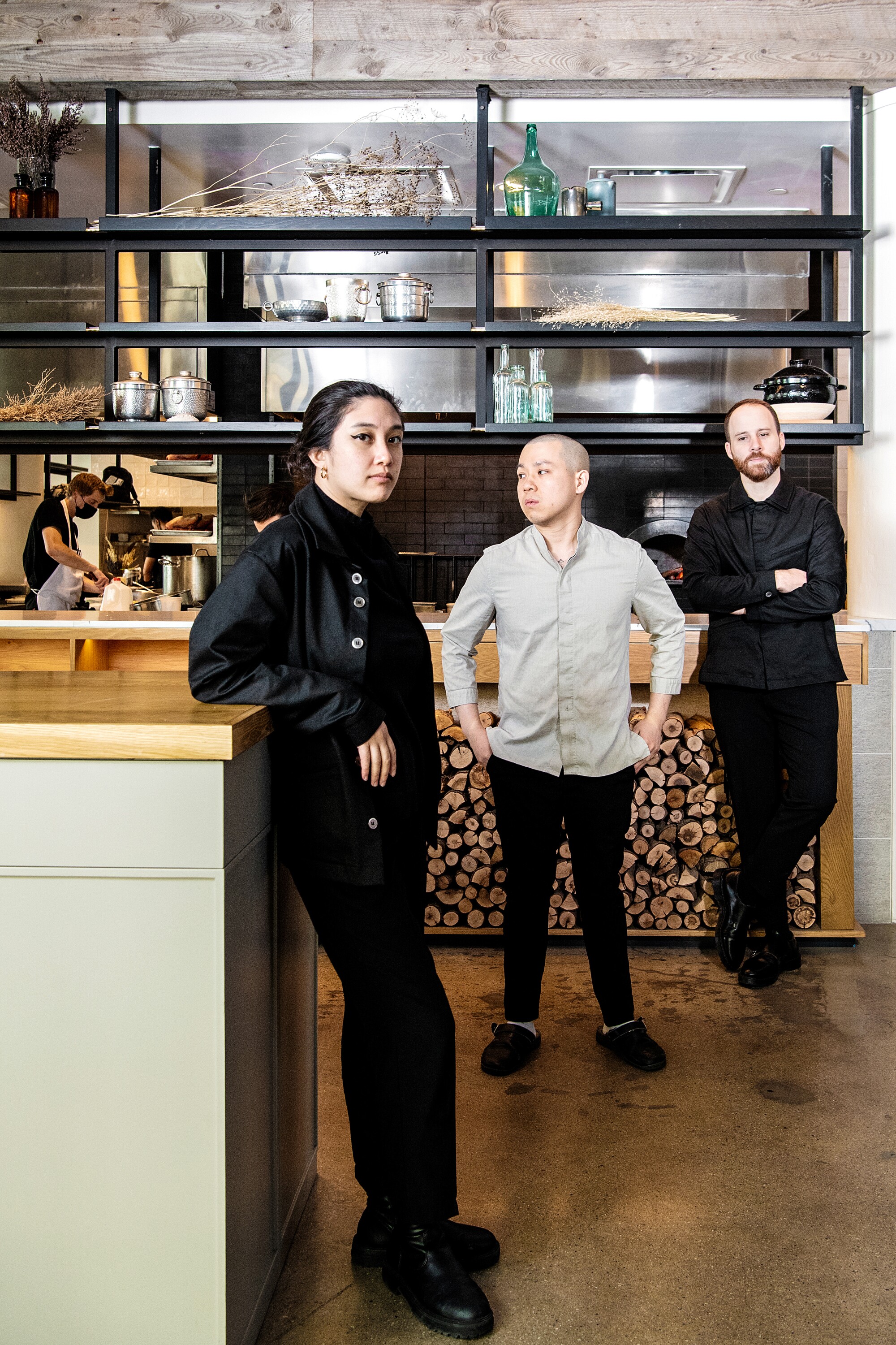 Three people pose for a portrait in a restaurant.