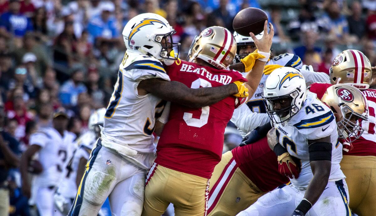 Chargers defensive back Derwin James (33) forces a turnover as he hits 49ers quarterback C.J. Beathard late in the fourth quarter Sunday.