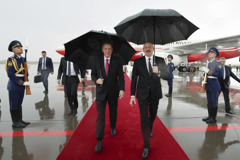 In this handout photo released by Turkish Presidency, Azerbaijan's President Ilham Aliyev, right, welcomes Turkey's President Recep Tayyip Erdogan in Nakhchivan, Azerbaijan, Monday, Sept. 25, 2023. Thousands of Armenians streamed out of Nagorno-Karabakh after the Azerbaijani military reclaimed full control of the breakaway region while Turkish President Recep Tayyip Erdogan visited Azerbaijan Monday in a show of support to its ally. (Turkish Presidency via AP)