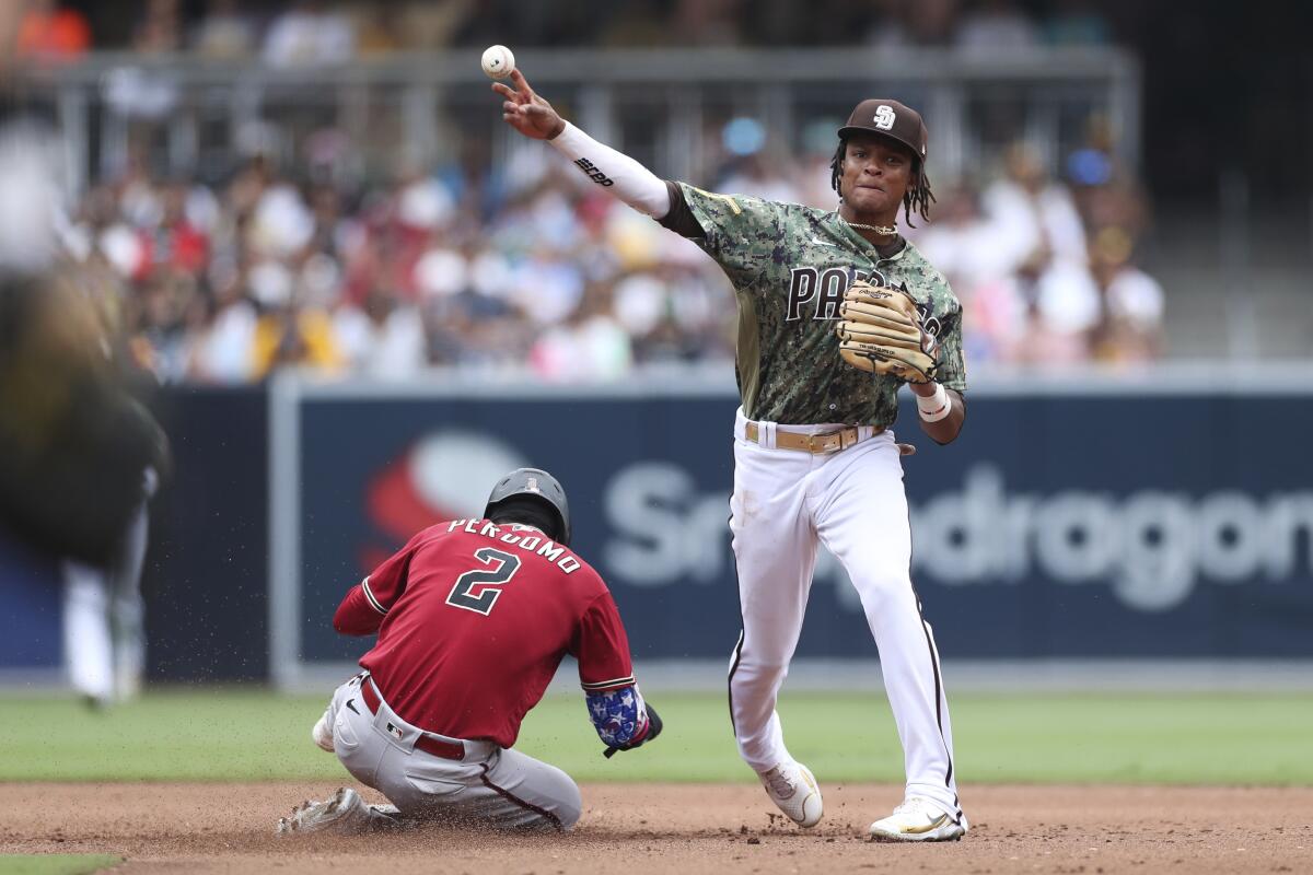 San Diego Padres shortstop C.J. Abrams, right, throws to first to complete a double play after forcing out Arizona Diamondbacks' Geraldo Perdomo at second base on a ball hit by Jose Herrera during the fifth inning of a baseball game Sunday, July 17, 2022, in San Diego. (AP Photo/Derrick Tuskan)