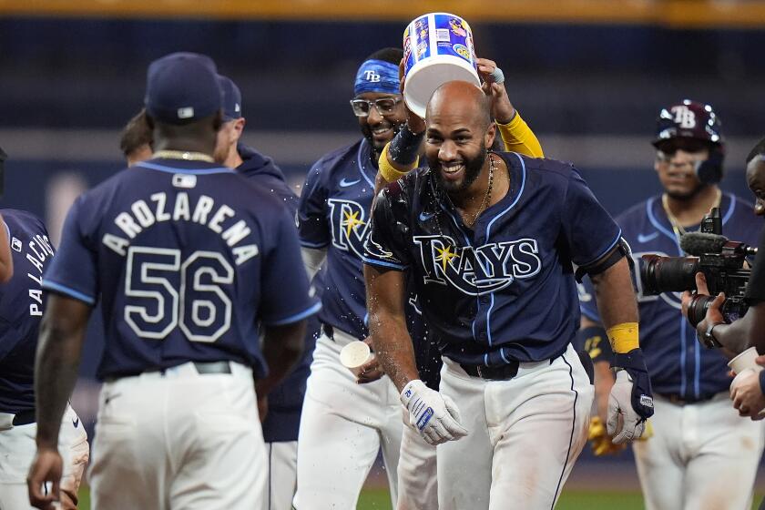 El dominicano Amed Rosario (derecha), de los Rays de Tampa Bay, festeja tras conectar el hit decisivo ante los Angelinos de Los Ángeles, el martes 16 de abril de 2024 (AP Foto/Chris O'Meara)