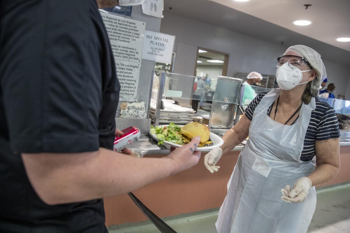 Teacher Jenny Kershner, right, helps serve lunch at the Union Rescue Mission in Los Angeles in July.