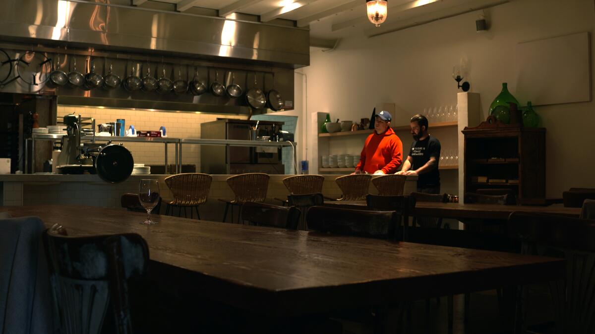 Chef Chad Colby and another man inside the empty Antico restaurant.