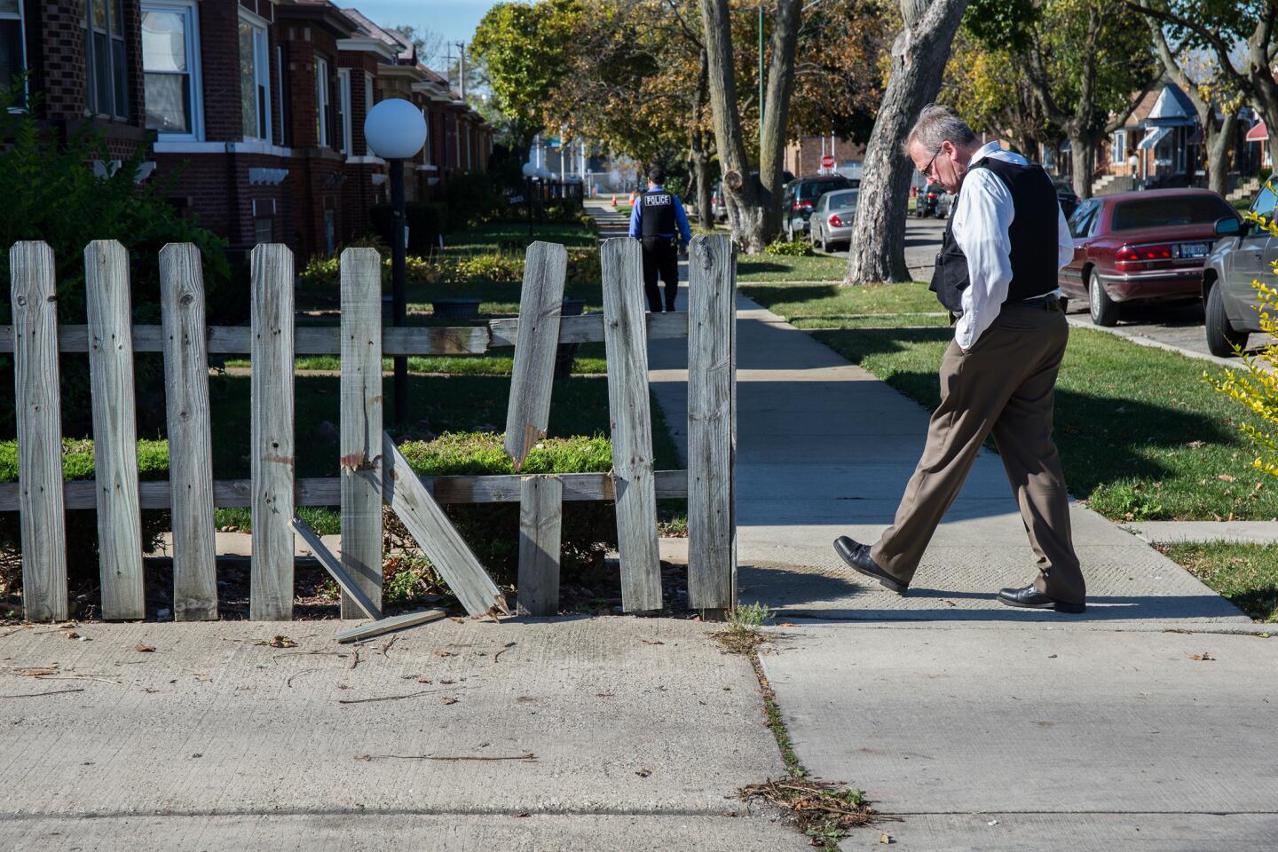 A Chicago police officer on Nov. 3, 2015, scans the area around the alley at 80th Street and South Damen Avenue, near where Tyshawn Lee, 9, was fatally shot the day before.