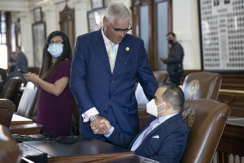 State Rep. Dan Huberty, R-Houston, left, greets Rep. Garnet F. Coleman, D-Houston in the House Chamber at the Capitol in Austin, Texas, on Thursday Aug. 19, 2021. A standoff in Texas over new voting restrictions that gridlocked the state Capitol for 38 consecutive days ended Thursday when some Democrats who fled to Washington, D.C., dropped their holdout, paving the way for Republicans to resume pushing an elections overhaul. (Jay Janner/Austin American-Statesman via AP)