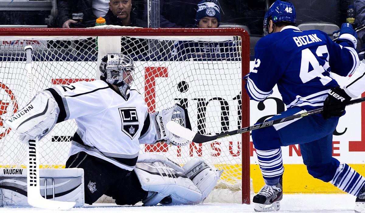 Kings goalie Jonathan Quick makes a save with his left pad on a shot by Maple Leafs forward Tyler Bozak in the first period Sunday evening in Toronto.