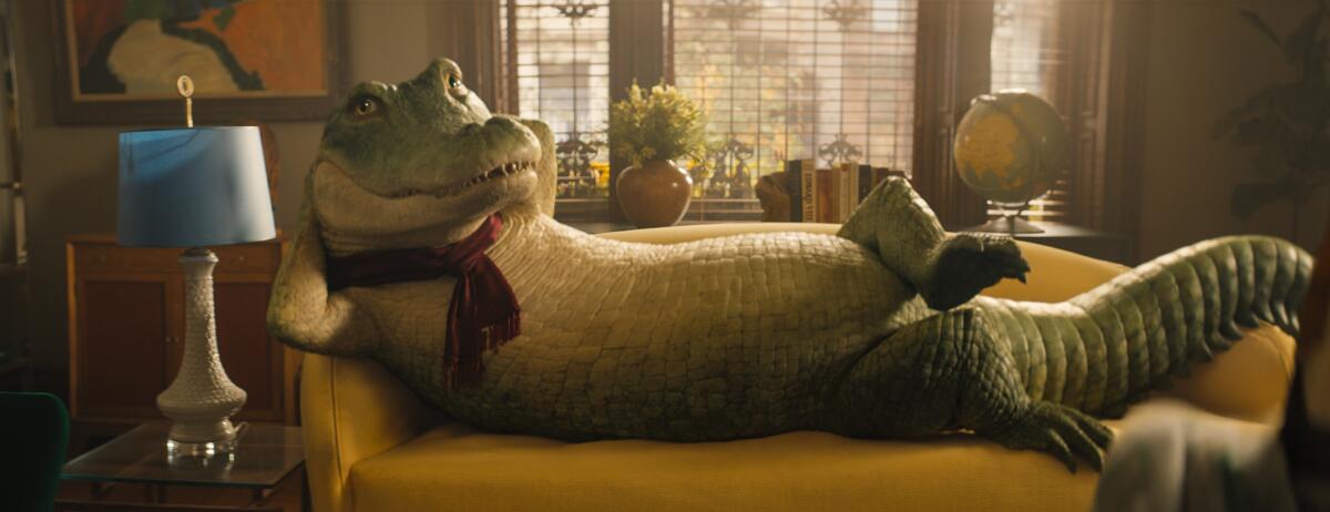 A crocodile wearing a scarf poses on a couch.