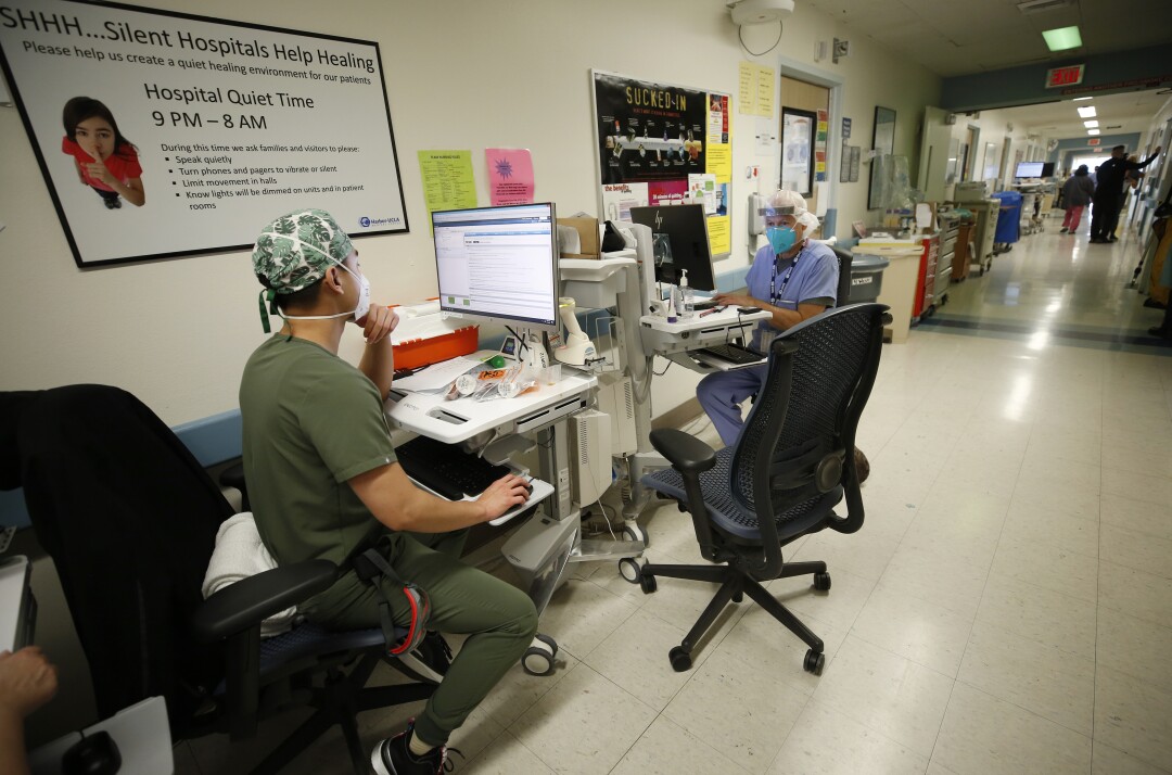 Two nurses at desks in Harbor-UCLA Medical Center. 