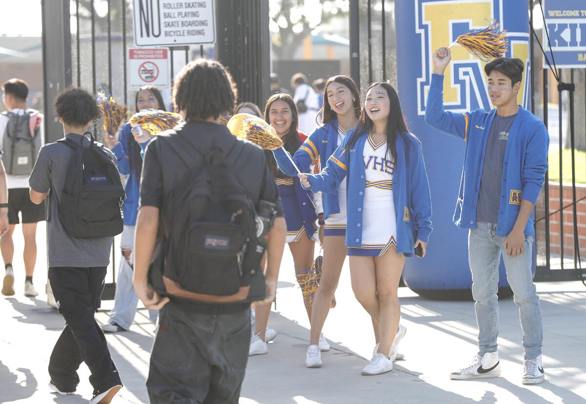 Members of the cheer squad greet students as they walk to class on the first day of the school year at Fountain Valley High.