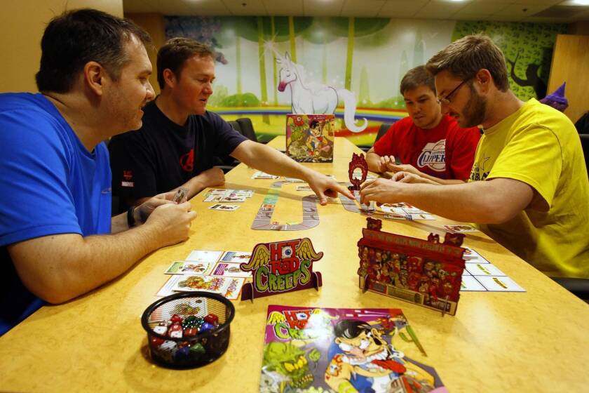 From left: Kyle Heuer, Matt Hyra, Will Brinkman and Phil Cape play Hot Rod Creeps, a card-driven racing game, at Cryptozoic Entertainment in Irvine, California.