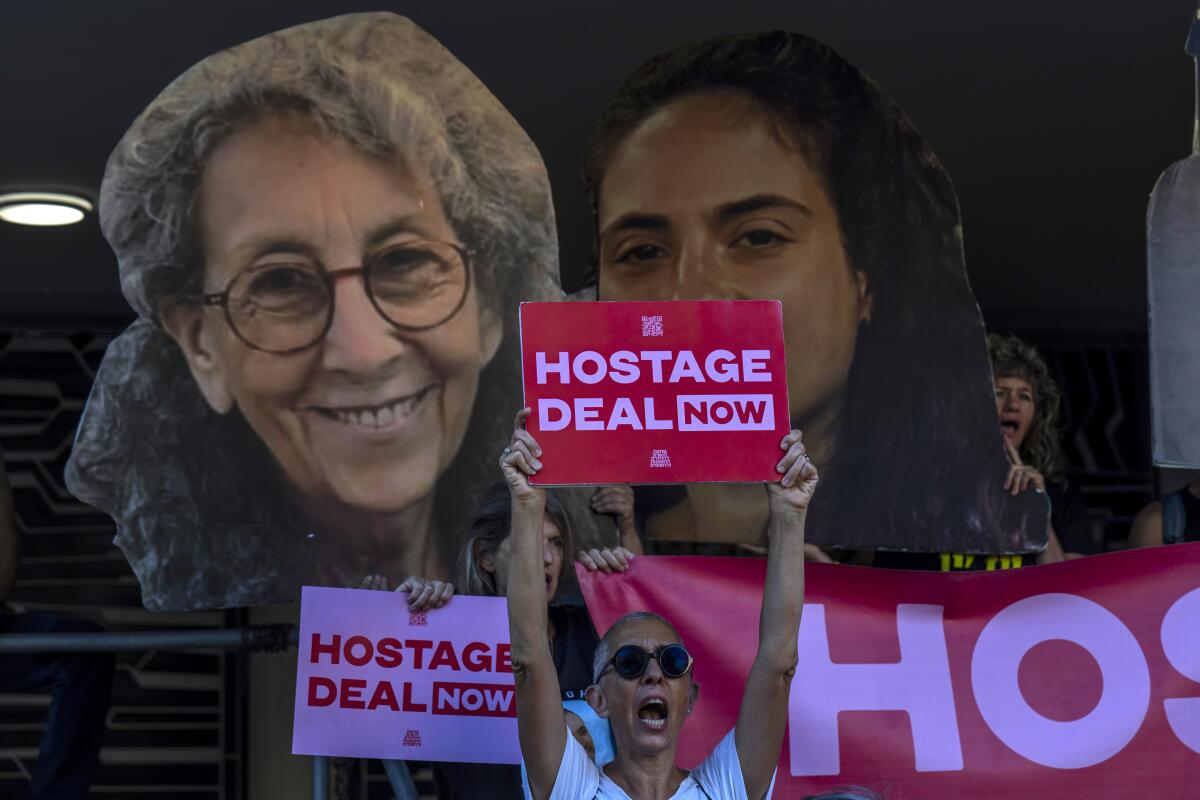 Relatives and supporters of Israeli hostages hold signs and photos of their loved ones.