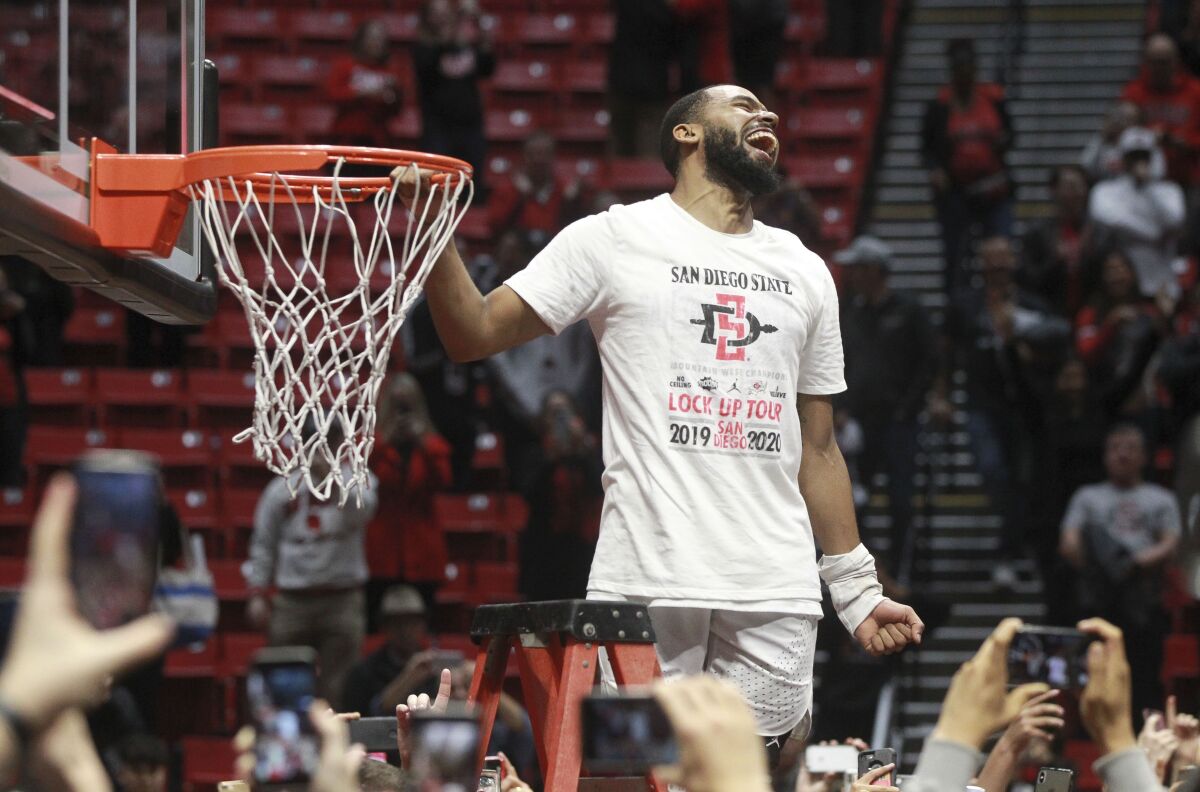 SDSU's KJ Feagin was the first Aztecs player to start cutting down the net after beating New Mexico on Feb. 11.