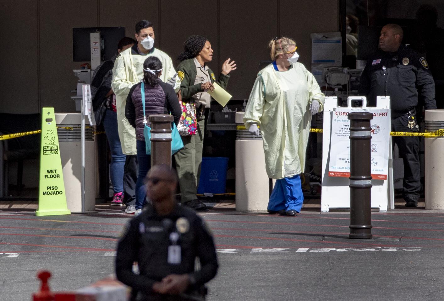 Medical personnel screen patients outside the emergency room at Loma Linda University Health during the coronavirus pandemic.