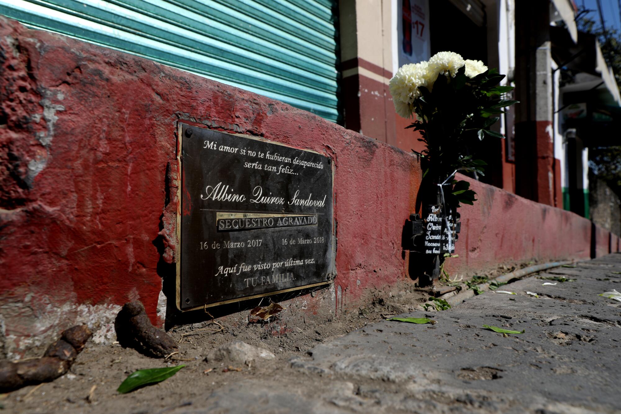 A marker inscribed with "aggravated kidnapping and here was last seen," in honor of Albino Quiroz Sandoval, in downtown Tepoztlán, Mexico, on Dec. 15.