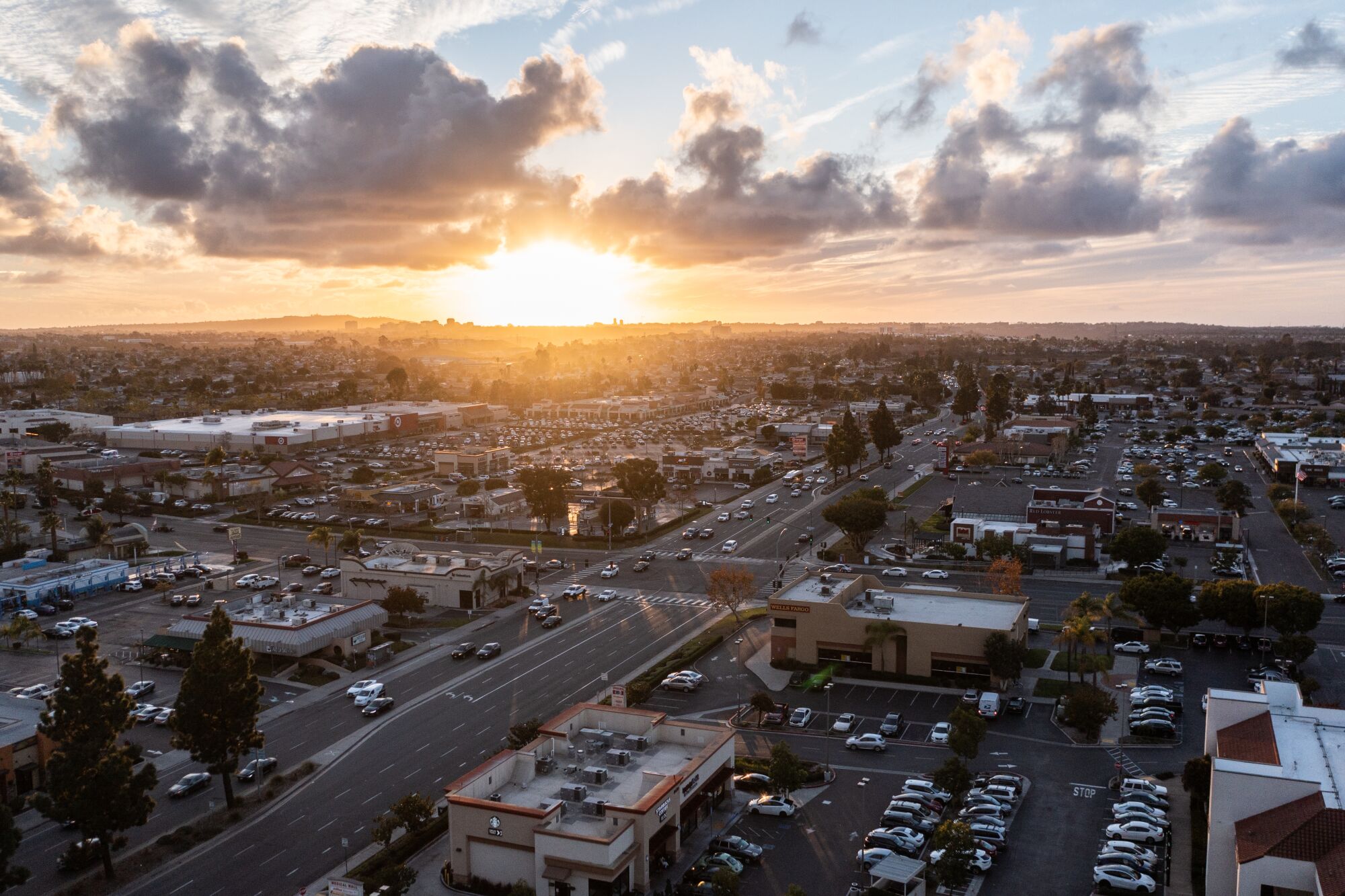 An aerial view of a suburban strip-mall neighborhood at sunset.