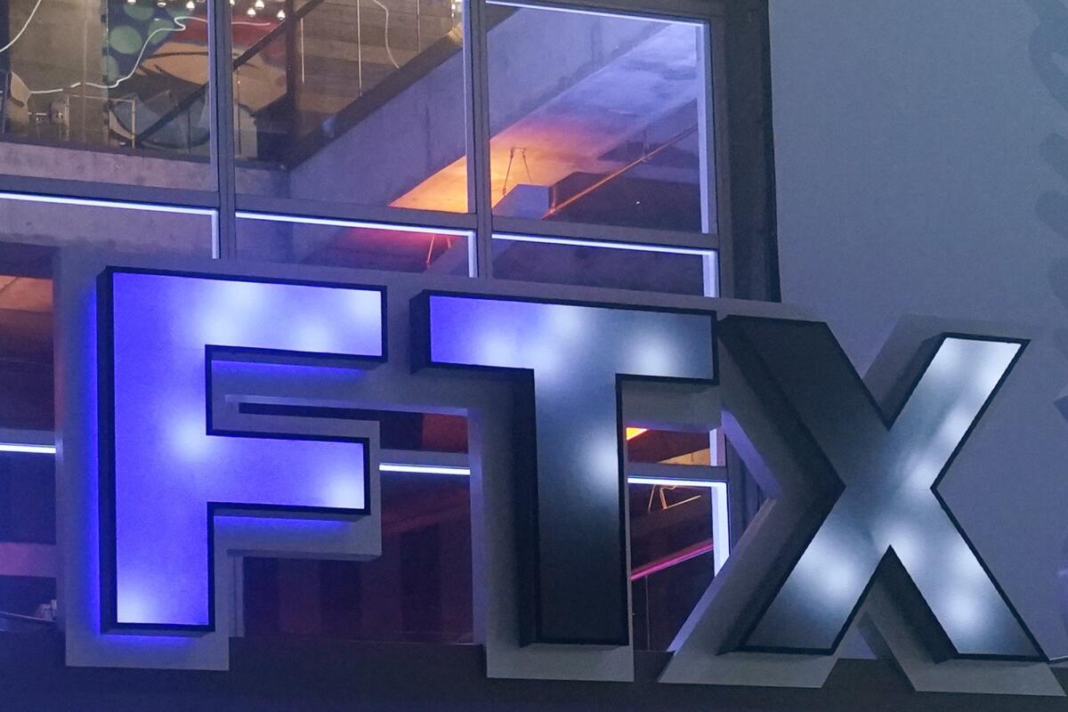 A logo for the company 'FTX' is seen outside of a building.