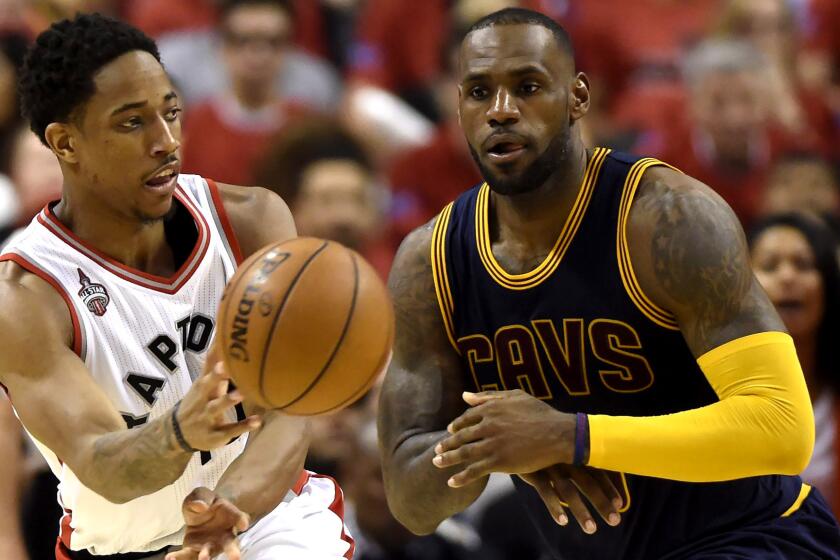 Raptors guard DeMar DeRozan flips a pass to a teammate after driving past Cavaliers forward LeBron James during the second half of Game 3 on Saturday.