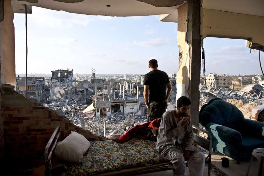 Men sit in a destroyed apartment building in the neighborhood of Al-Shaas in the Gaza Strip. The men's families live in a U.N.-run school where they had taken refuge, but the men remain and sleep overnight in the shell of a building to watch over what little is left.