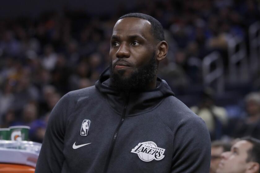 Los Angeles Lakers' LeBron James watches from the bench during the first half of the team's preseason NBA basketball game against the Golden State Warriors on Friday, Oct. 18, 2019, in San Francisco. (AP Photo/Ben Margot)