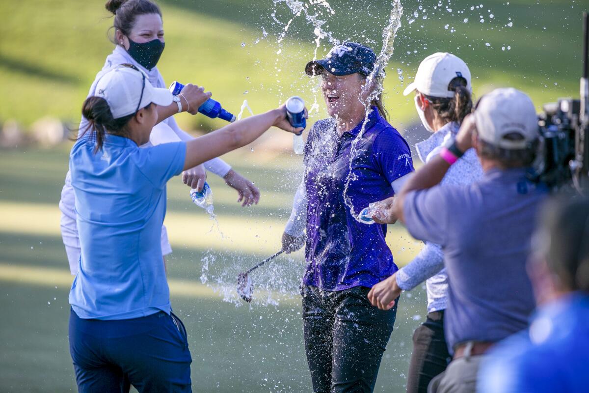 Austin Ernsts celebrates her win and gets a beer bath from fellow golfer Danielle Kang at the final round of the LPGA golf tournament in Ocala, Fla., Sunday, March 7, 2021. (Alan Youngblood/Ocala Star-Banner via AP)