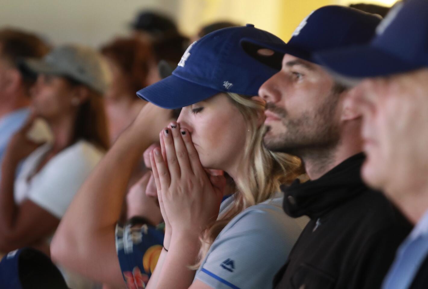 A Dodger fan prays as Game 3 goes into extra inning.
