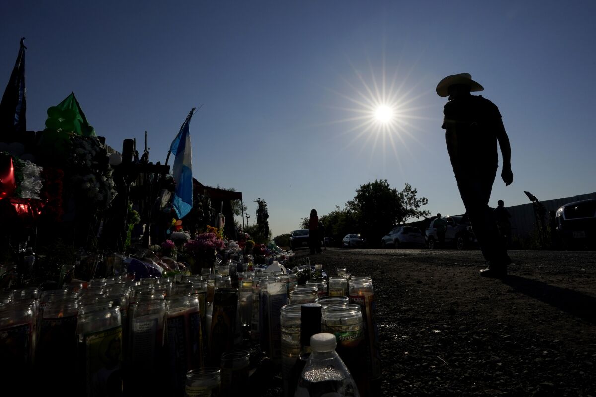 ARCHIVO - Cruces, velas, banderas y botellas de agua están desplegados para un memorial improvisado en el lugar donde decenas de presuntos migrantes murieron en un camión con remolque abandonado, el jueves 30 de junio de 2022, en San Antonio. (AP Foto/Eric Gay, Archivo)