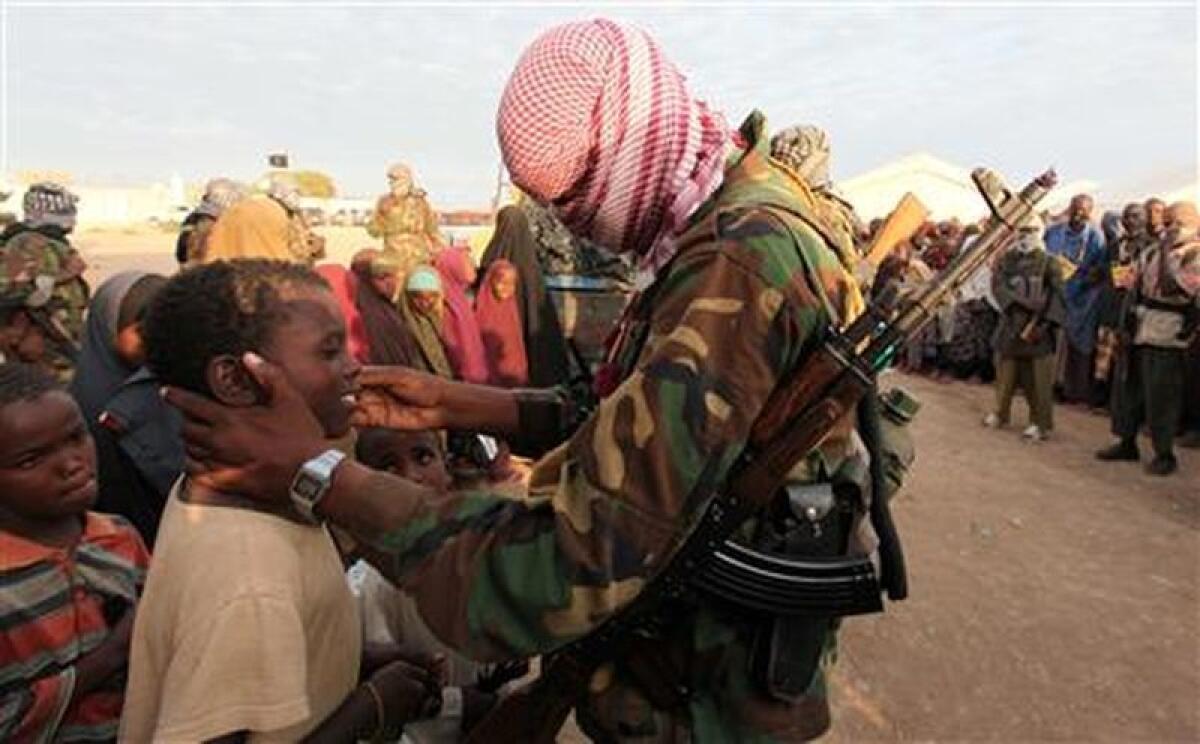 Un integrante de Al Shabaab —insurgentes ligados a al Qaeda— conversa con niños refugiados somalíes en Ala Yaasir.