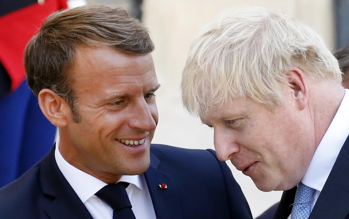 French President Emmanuel Macron accompanies British Prime Minister Boris Johnson after their meeting at the Elysee Presidential Palace on Thursday in Paris. Johnson was on an official visit prior to attending the Group of 7 summit in Biarritz, France.