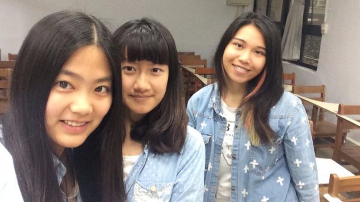 Wang Hao, left, a university undergraduate from northeastern China, poses with a fellow mainland Chinese student, center, and a local classmate at Ming Chuan University in Taipei, Taiwan.