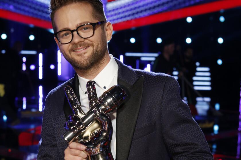 Josh Kaufman holds the trophy he won after placing first on the singing competition series "The Voice" on NBC.