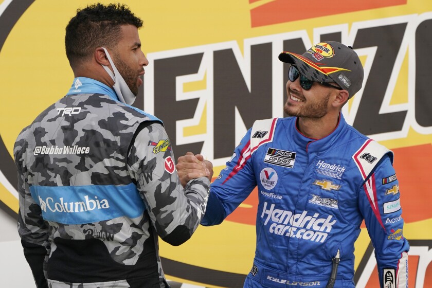 Bubba Wallace, left, congratulates Kyle Larson after Larson won a NASCAR Cup Series auto race Sunday, March 7, 2021, in Las Vegas. (AP Photo/John Locher)