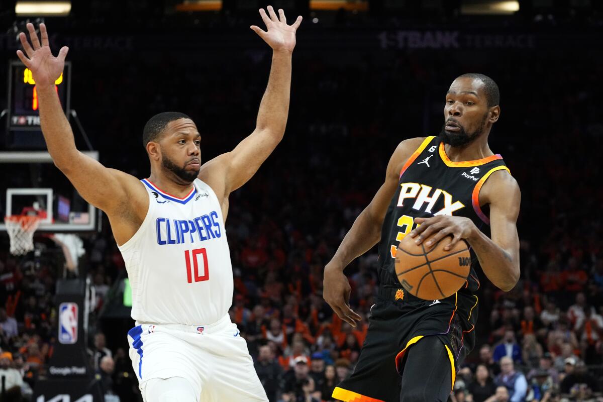 Los Angeles Clippers guard Eric Gordon throws up his arms while defending against Phoenix Suns forward Kevin Durant